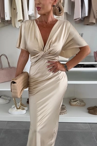 Détail du design torsadé élégant et du tissu en satin soyeux sur la robe couleur champagne