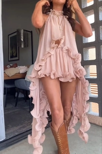 Detail of pink chiffon sleeveless dress featuring ruffled high-low hem and halter neckline
