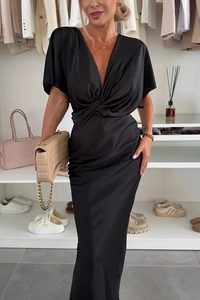 Détail de robe élégante en satin noir avec buste torsadé et décolleté en V profond