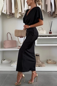 Détail de robe longue en satin noir avec col en V profond et manches chauve-souris