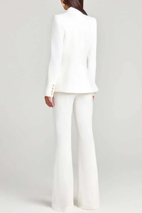 Detail of white blazer sleeves with four elegant gold buttons and tailored fit design