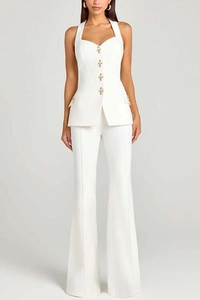 Detail of white waistcoat with gold cross buttons and matching high-waisted flare trousers