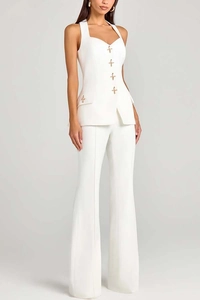 Detail of white waistcoat with gold cross buttons and matching wide-leg dress trousers