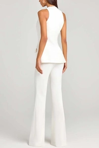 Detail of white peplum sleeveless top with gold buttons and flare suit trousers