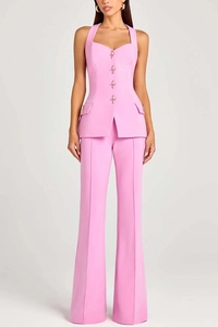 Detailed view of pink three-piece suit with golden decorative buttons and tailored trousers