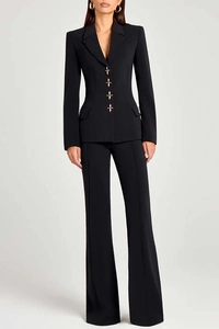 Detail of four golden embossed cross buttons on a slim-fit black blazer waist