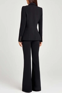 Rear view of black slim fit blazer and flared trousers with gold cuff buttons