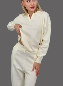 Détail d'un ensemble en maille crème avec pull polo et pantalon à taille coulissante