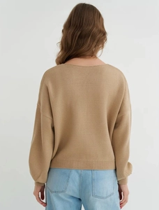 Back view of a camel knitted loose cardigan with ribbed cuffs and drop shoulder style