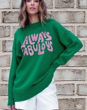 Detailed knit texture of green oversized sweater with pink Always Fabulous graphic