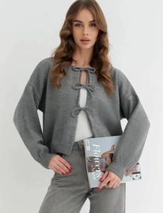 Detail of grey knitted cardigan with three bow tie closures and stylish ribbed cuffs