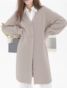 Detail view of khaki long knit cardigan with V-neckline and ribbed cuffs on sleeve
