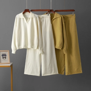 Détail d'un ensemble en maille avec pull polo à col en V et pantalon large en crème et moutarde