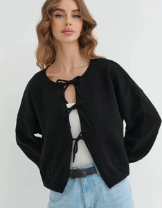 Detail view of black knit cardigan with three elegant front bow ties and ribbed cuffs