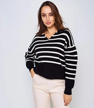 Close-up of black and white striped knit sweater with V-neckline and ribbed cuffs