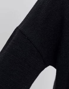 Close-up detail of high-quality black knitted fabric texture and seamless stitching