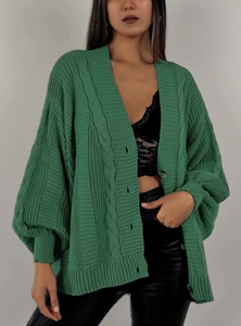 Détails d'un cardigan vert foncé avec maille torsadée épaisse et boutons ronds ton sur ton