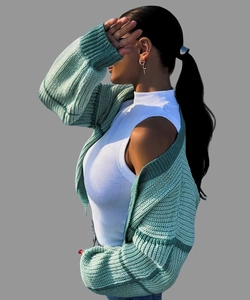 Detailed close-up of mint green chunky knit cardigan with heavy texture and ribbed cuffs