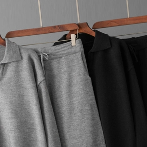 Détail d'un ensemble pull polo en maille et pantalon à cordon en gris foncé et noir
