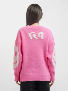 Detail view of the pink knit sweater showing the soft texture and smiley face on sleeves