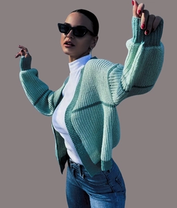 Detail of chunky knit mint green cardigan featuring dark green stripes and drop shoulders