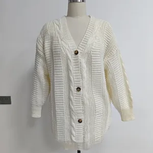 Détail du cardigan blanc en maille torsadée avec boutons marrons et texture d'encolure en V