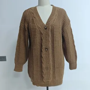 Détail du cardigan en maille épaisse avec torsades marron et grands boutons ronds