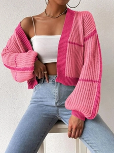 Close-up of pink patchwork chunky knit cardigan with textured stripe and check patterns
