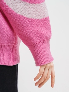 Close-up of pink and white striped knit sweater with fluffy mohair texture and ribbed cuff