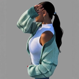 Women's autumn knit cardigan in green stripes over a sleeveless white turtleneck sweater