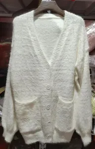 Detailansicht der weißen Plüsch-Strickjacke mit weicher Textur und großen vorderen Taschen