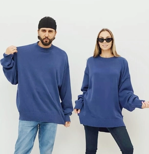 Détail du pull en maille bleue montrant les bords-côtes et la coupe unisexe oversize