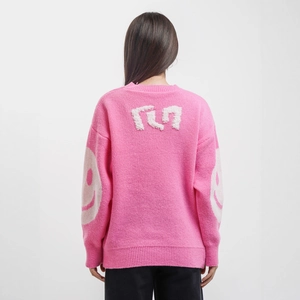 Pink oversized knit sweater with white fuzzy letters and smiley face prints on sleeves