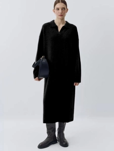 Front view of model in black knitted polo maxi dress with V-neckline and long sleeves