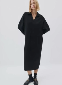 Detail of elegant black long-sleeve knit dress featuring a polo collar and V-neck cut