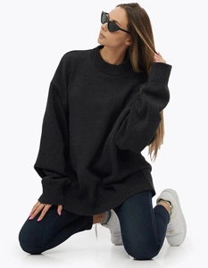 Détail du pull en maille noire oversize avec poignets côtelés et épaules tombantes