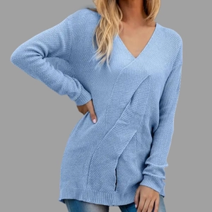 Detail of light blue V-neck knit sweater featuring a cross-wrap design and ribbed cuffs