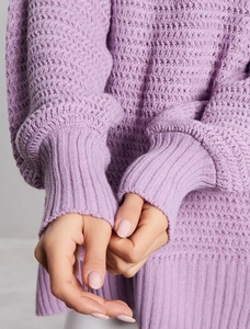 Detailed view of lavender knit sweater texture and ribbed cuff design on the sleeve