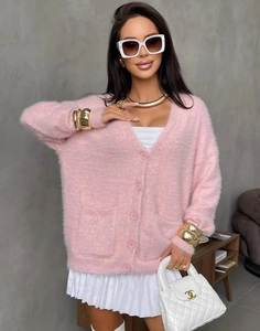 Detail der rosa Strickjacke aus Webpelz mit weicher Textur, Knöpfen und aufgesetzten Taschen