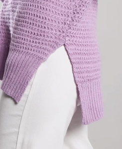 Detail view of light purple knit sweater showing side slit and ribbed hem texture