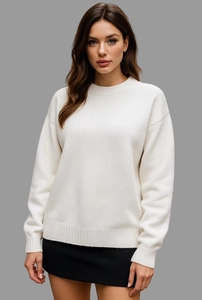 Gros plan d'un pull en maille blanc crème avec col rond et finitions en côtes aux poignets