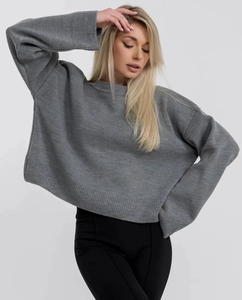 Dettaglio del maglione in maglia grigia oversize con trama morbida e polsini a costine