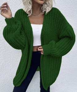 Detail of dark green chunky knit cardigan with textured woven surface and loose fit