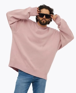 Détail d'un pull en maille rose surdimensionné avec poignets côtelés et col rond