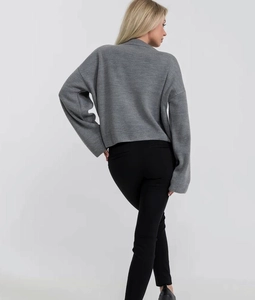 Vista posteriore del maglione grigio in maglia ampia con spalle scese e polsini