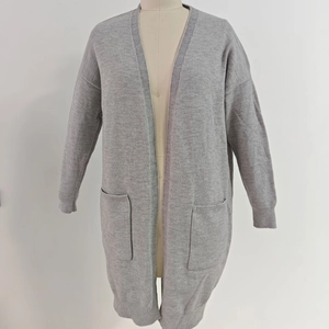 Macro view of grey knit cardigan featuring large side pockets and ribbed cuffs detail