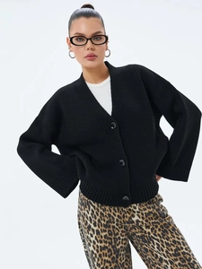 Détail du tricot épais et des boutons ronds noirs sur ce cardigan en maille pour femme