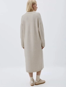 Detail view of the back of a beige knitted maxi dress with a soft texture and loose fit