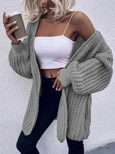 Detail of grey chunky knit cardigan showing heavy cable texture and puff sleeves