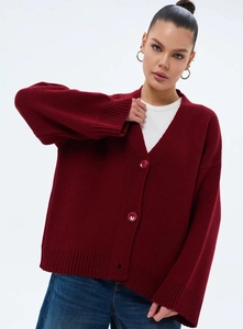 Détail d'un cardigan en maille bordeaux avec col en V et boutons assortis